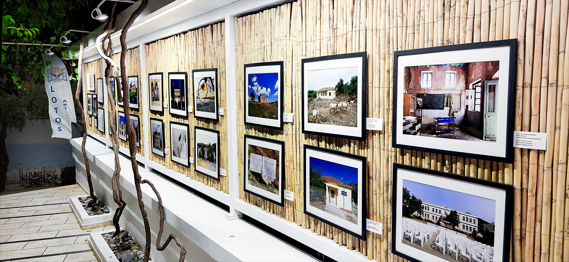 Nighttime view of LOTOS Open Art Gallery in Sougia, Chania, Crete, showcasing a contemporary art exhibition illuminated by atmospheric lighting that enhances the artworks and the unique character of the gallery space.